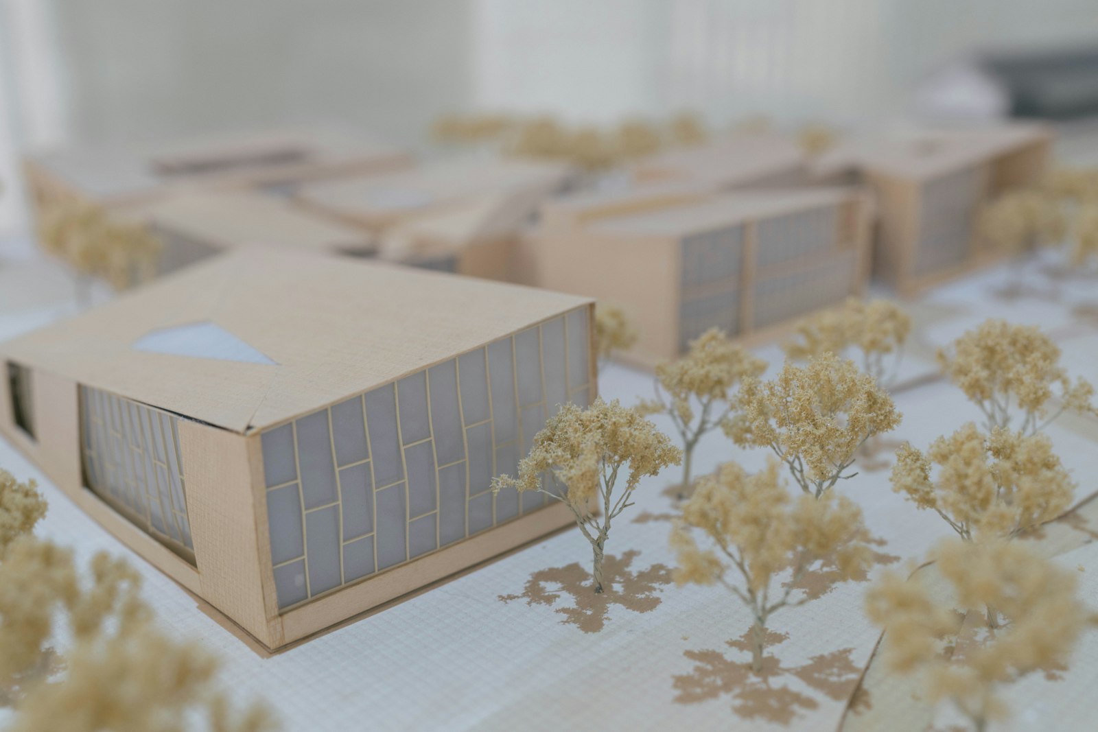 Architectural scale model of a small building on a studio desk.