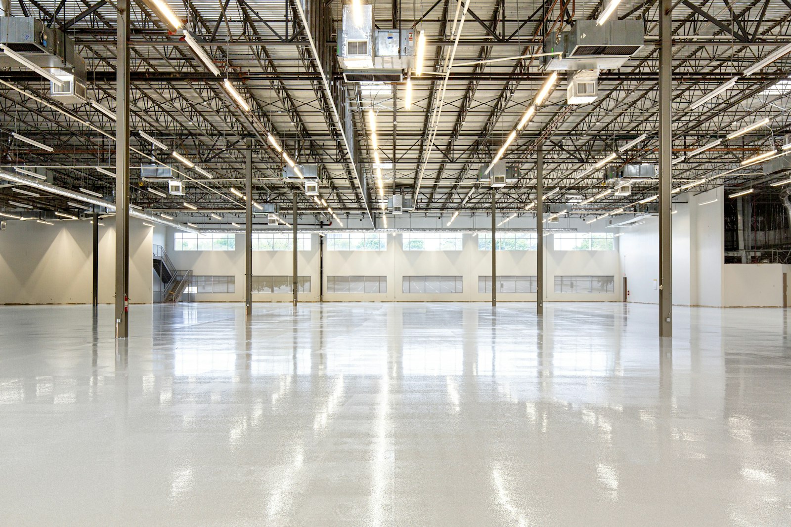 Adaptive reuse industrial interior with polished concrete floor and high open ceiling.