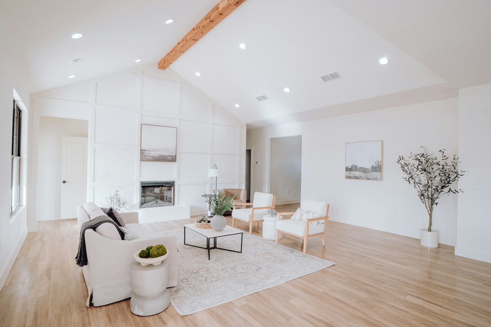 White-walled residential interior with wood floors and daylight from a large window.