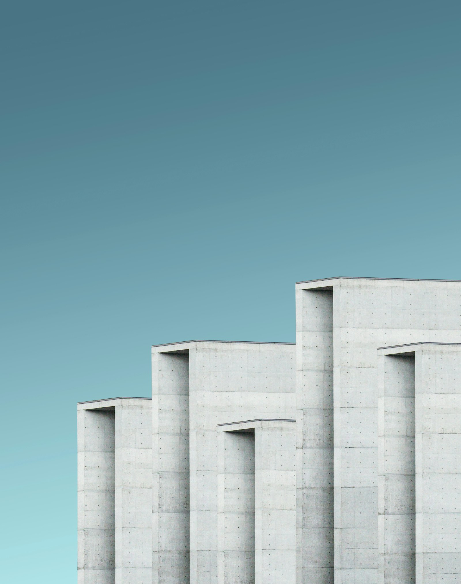 Geometric concrete facade detail — repeating monolithic forms in even daylight.