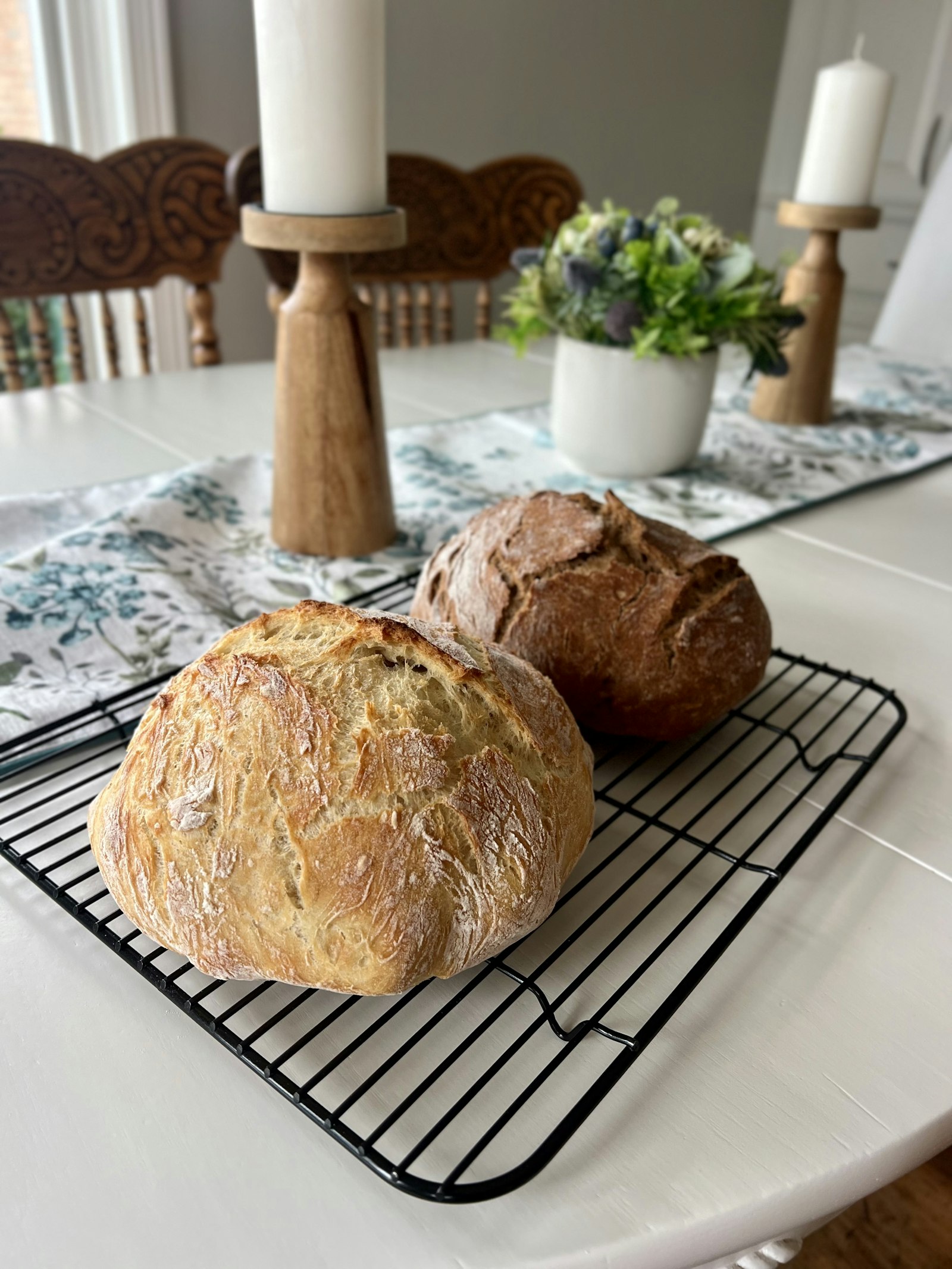 Two artisan loaves cooling on a wire rack after the morning bake