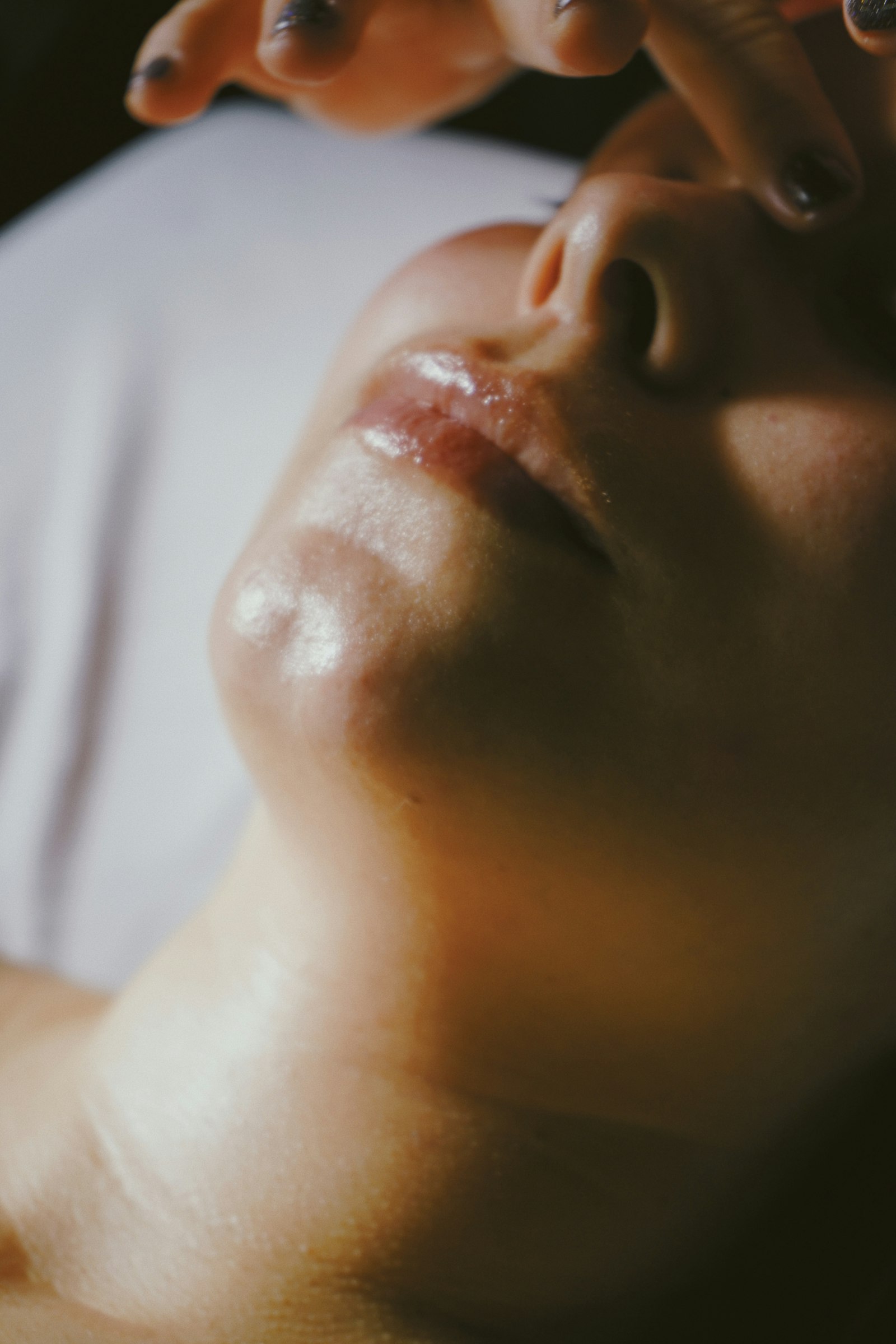 An esthetics treatment bed with a facial in progress under warm lamp light.