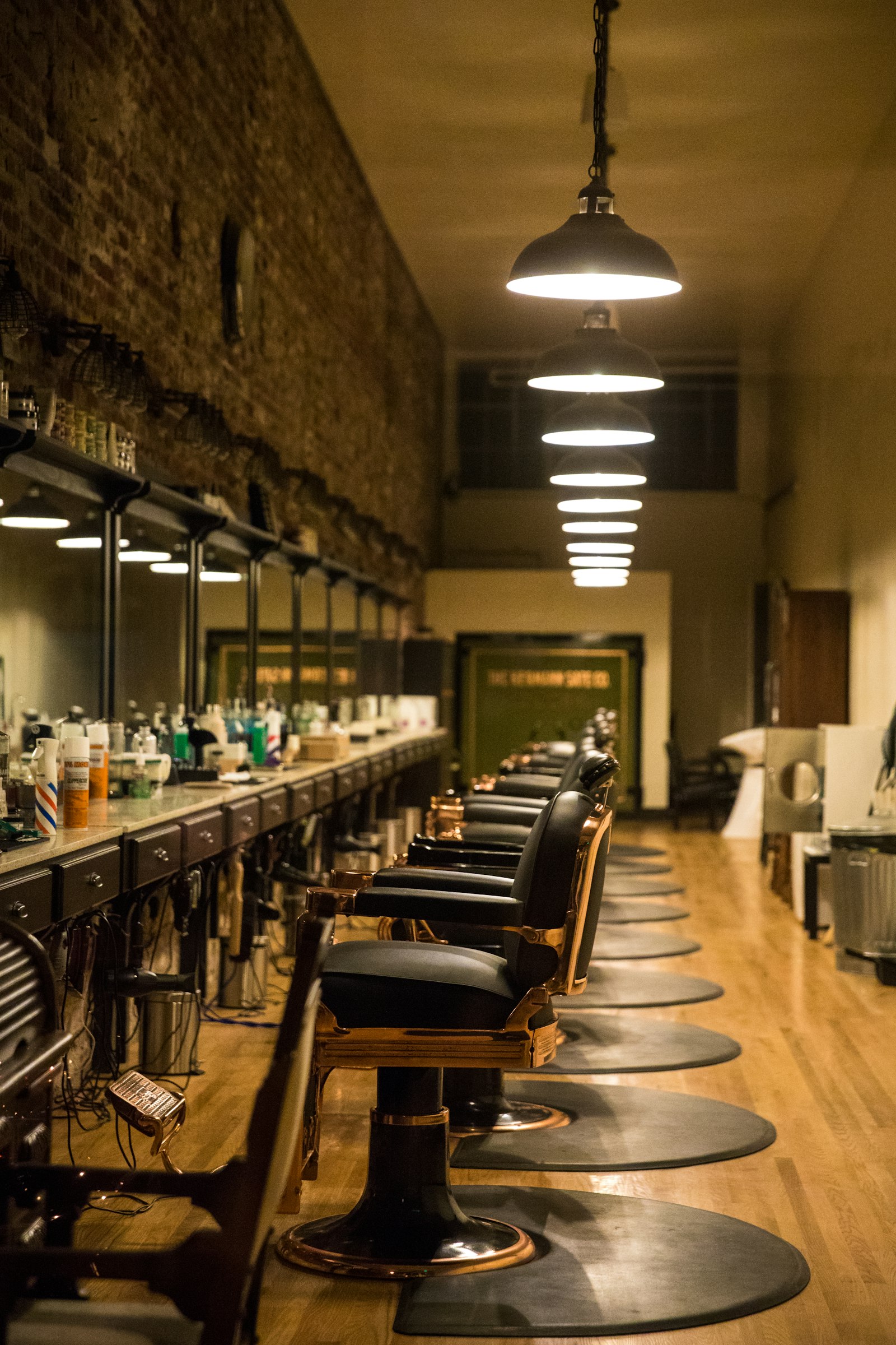 The main campus salon interior with pendant lighting over the styling row.
