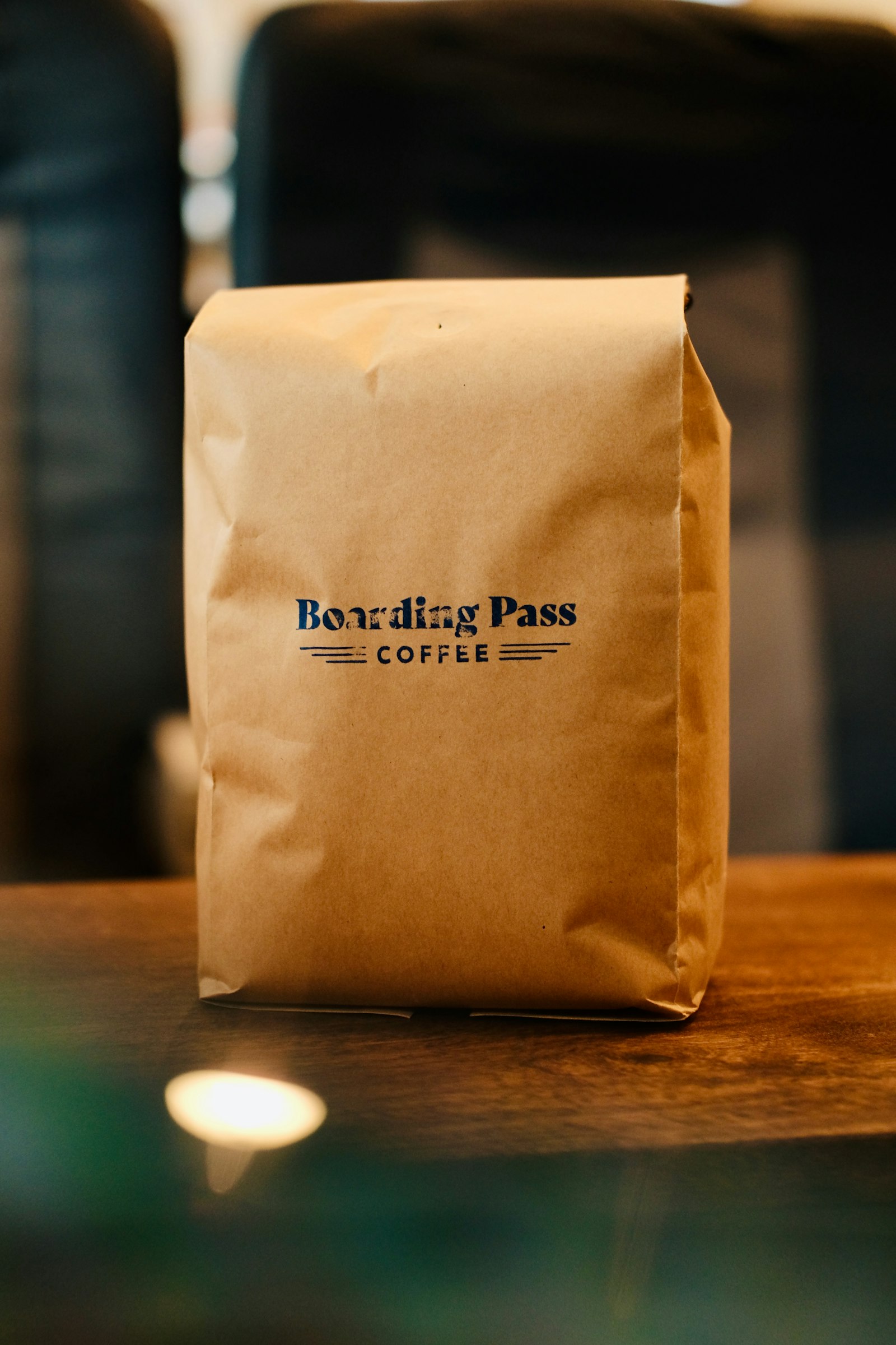A brown paper coffee bag resting on a wooden table