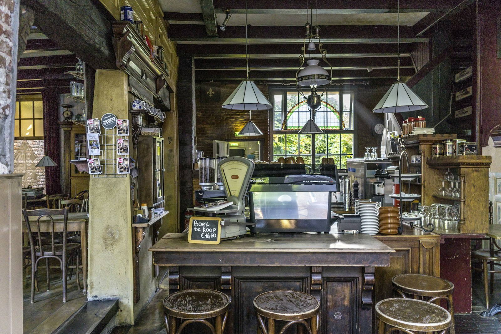 Brown wooden stools arranged around a wooden table inside the cafe
