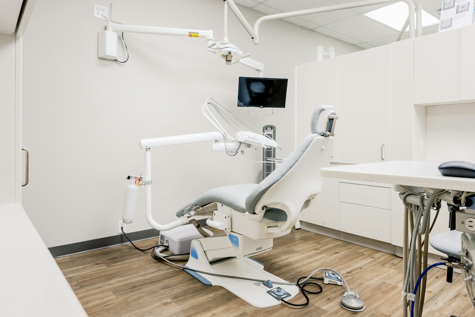 A bright, modern dental clinic room with a desk and chairs, calm and welcoming.