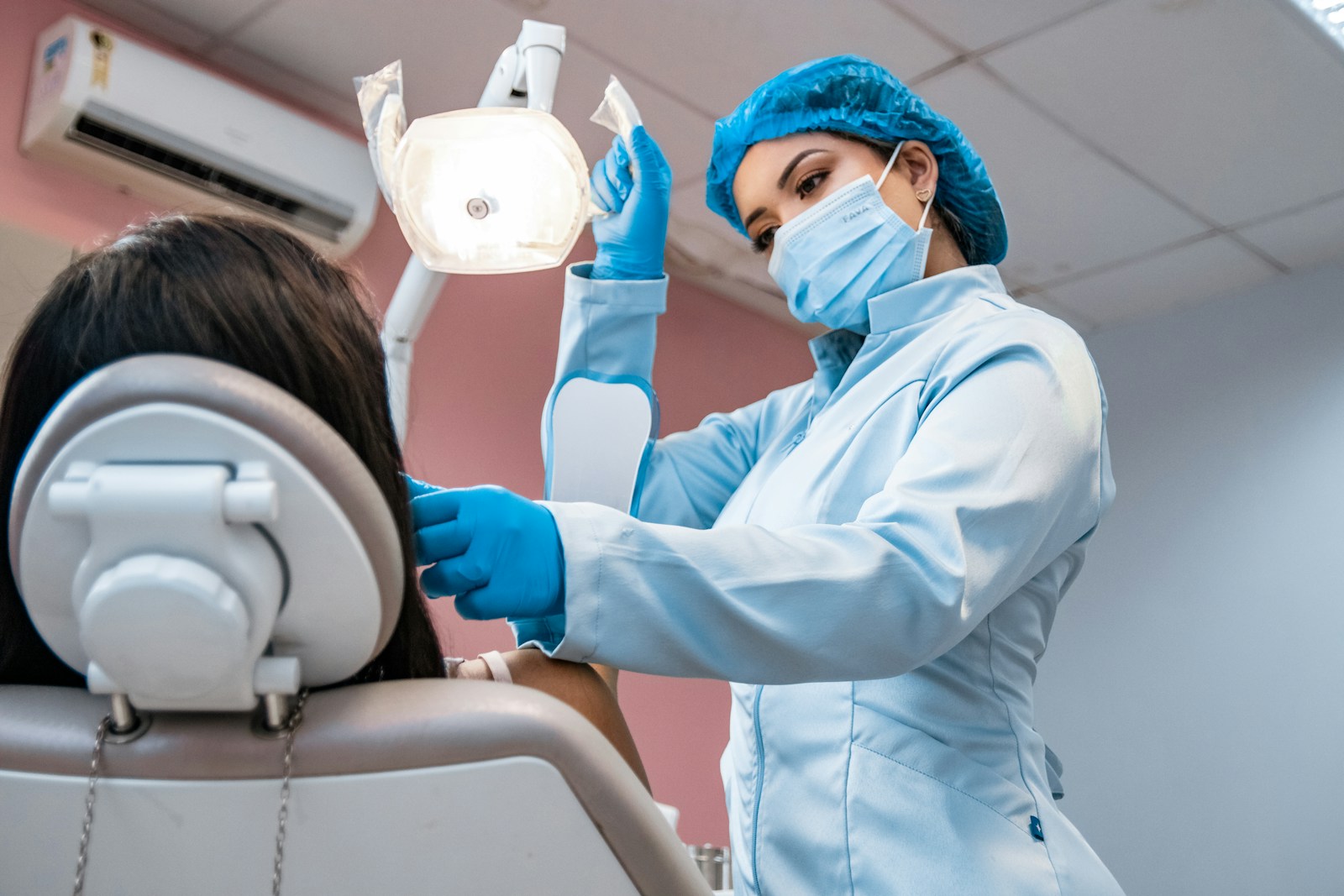 A dental hygienist gently brushing and polishing a patient's teeth during a routine cleaning.
