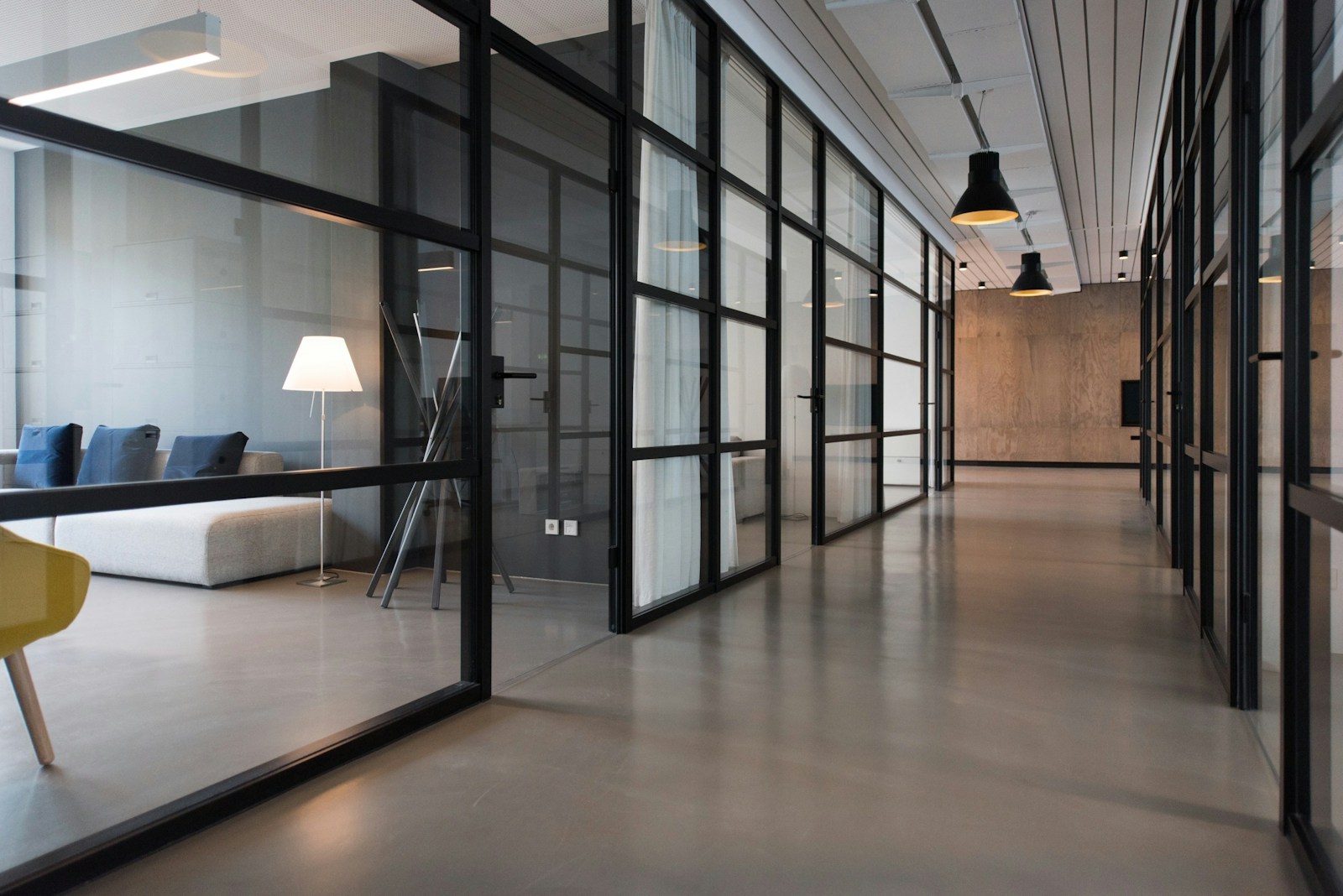 A quiet clinic hallway between glass-panel doors at the end of the day.