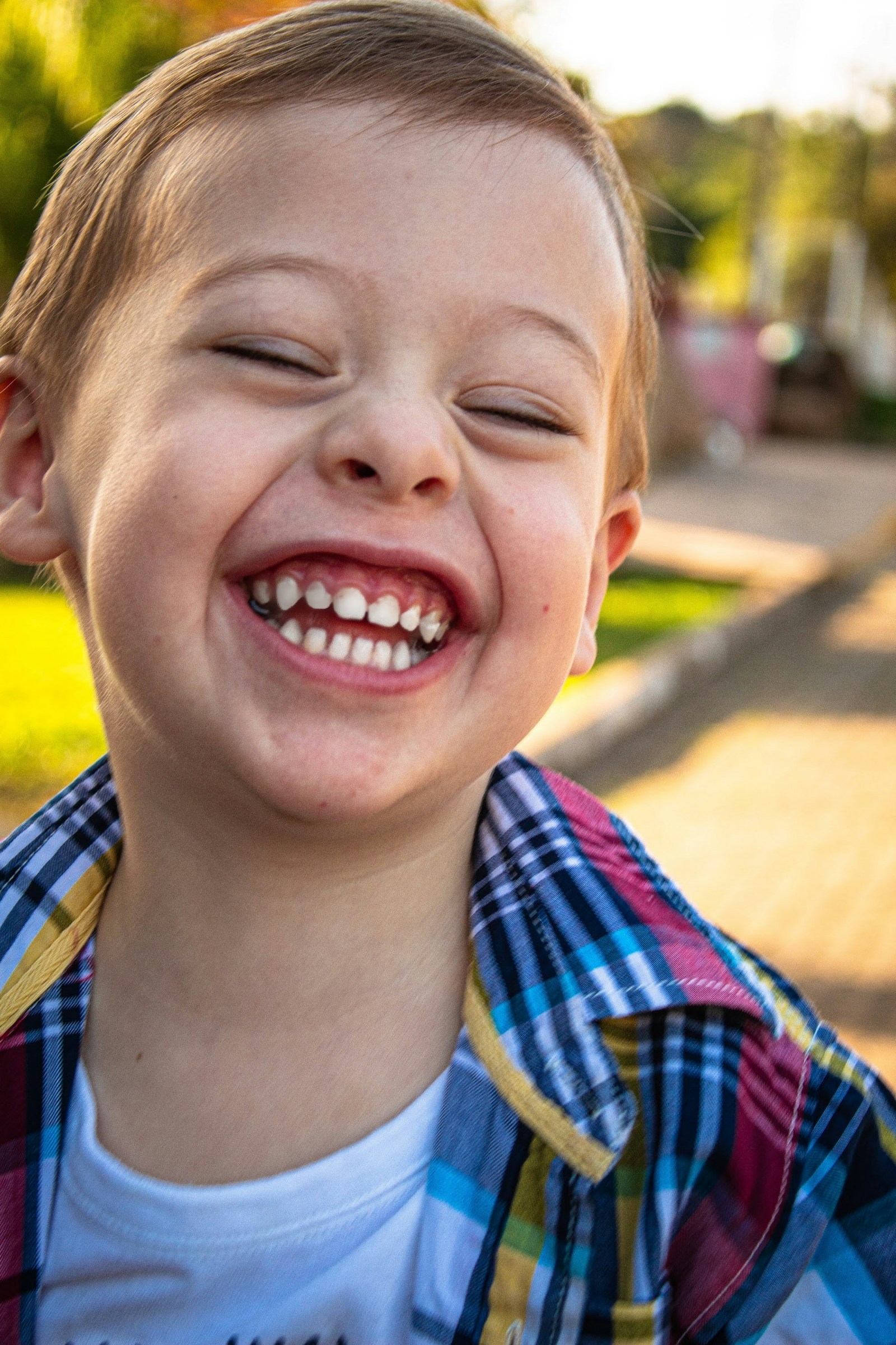 A boy in a plaid shirt smiling — the kind of smile a first visit is supposed to leave behind.