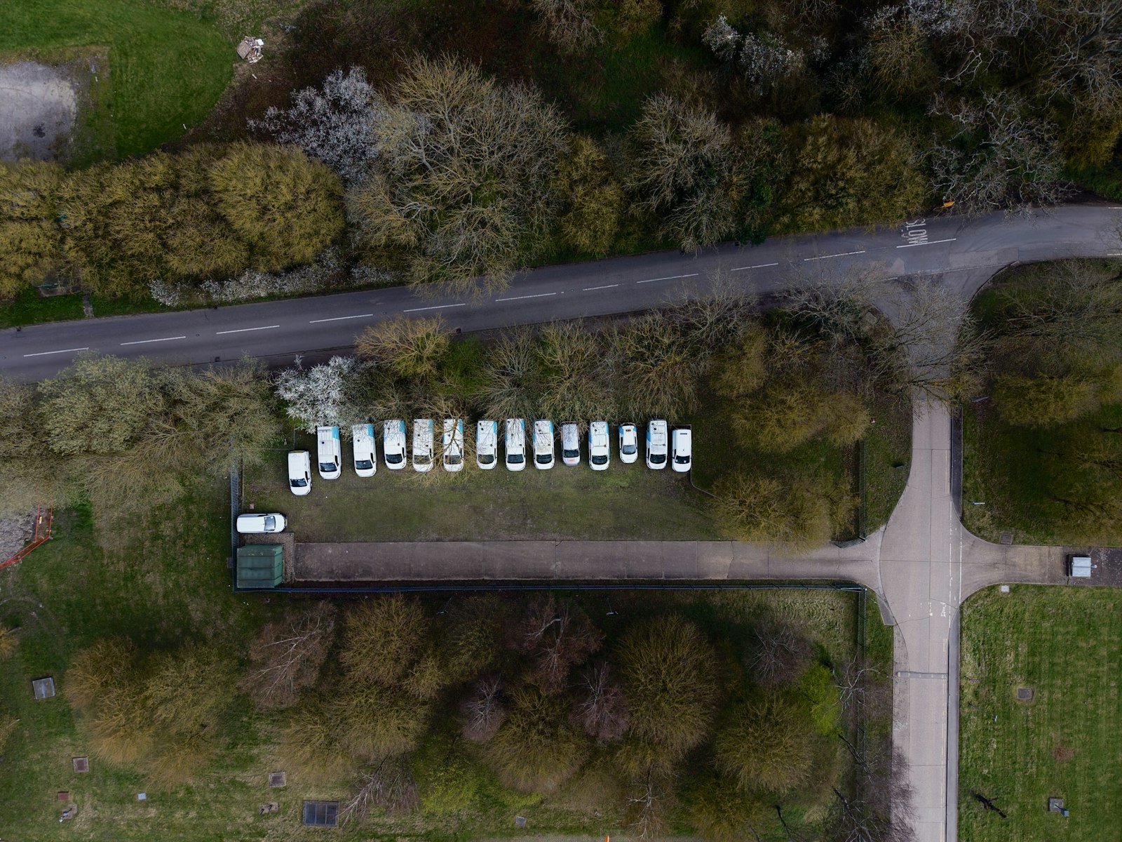 Overhead view of a fleet of white service vans lined along a road