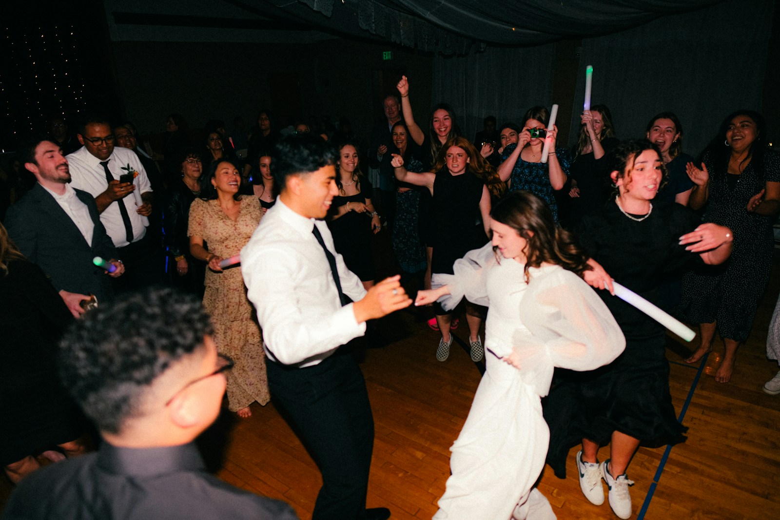 A close, candid moment on a crowded dance floor under low light.