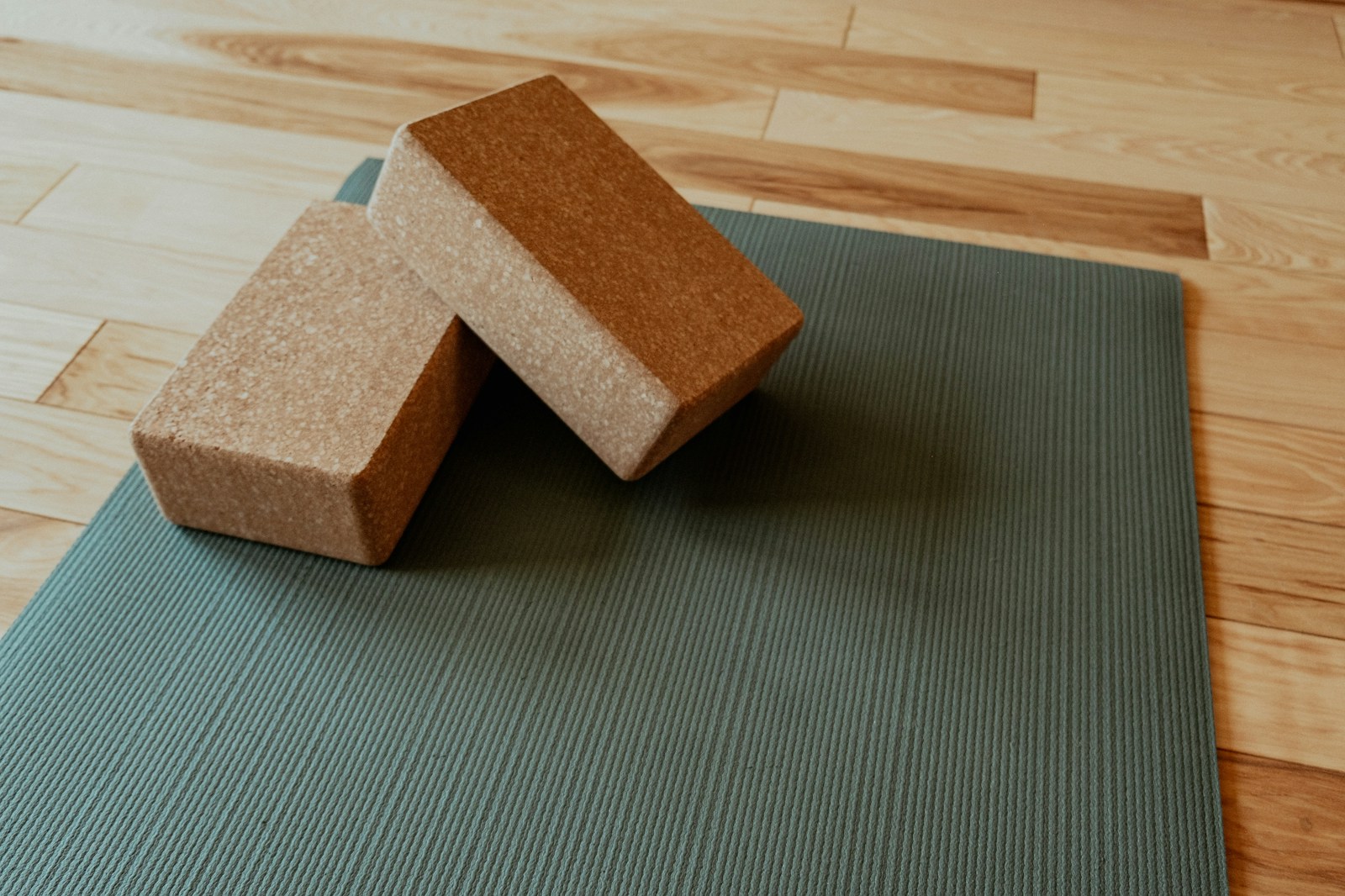 Single yoga mat laid out with two cork blocks resting on top