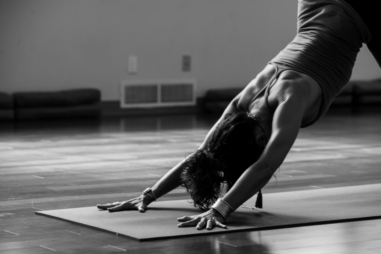 Teacher demonstrating a forward fold on a single mat in a quiet studio