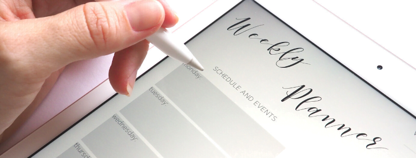 A woman using a touch-pen to write in her weekly planner on an iPad.
