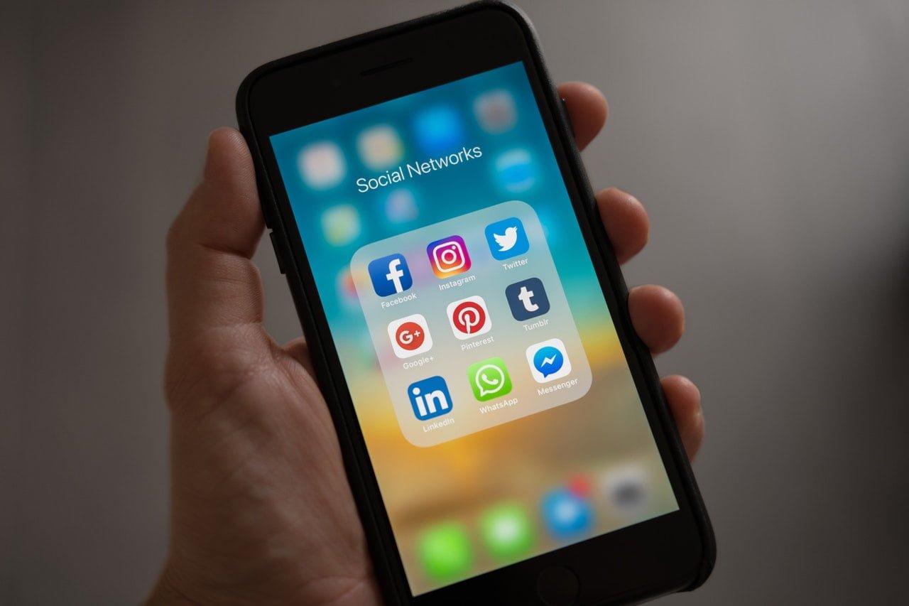 An iPhone app drawer open with social media apps in it.