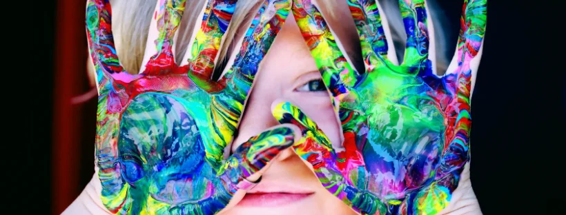 Mess Kid with colorful paint on his hand.