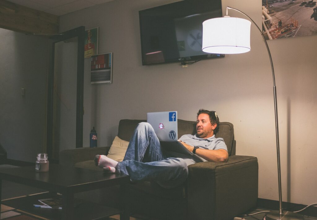 Man sitting on a sofa working on his laptop.