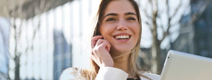 Reduced Risks A happy virtual assistant talking on a mobile phone and holding an iPad.