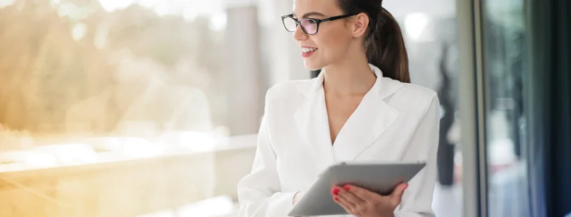 A professional lady happily working on her iPad.