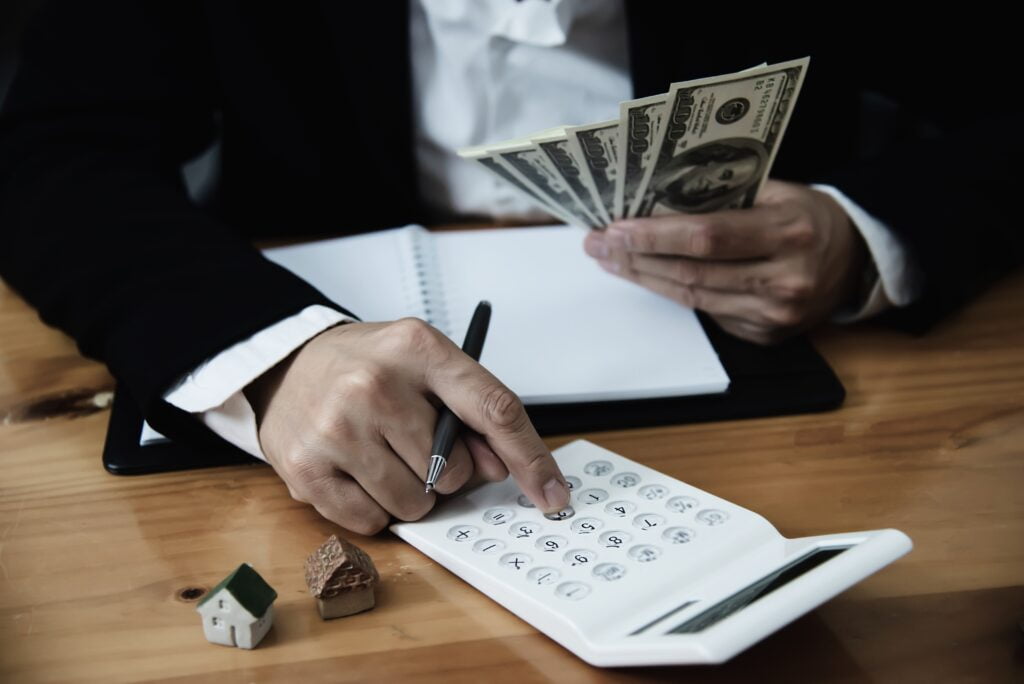 person holding money dollars calculating