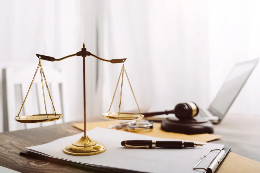 Business and lawyers contract papers with brass scale